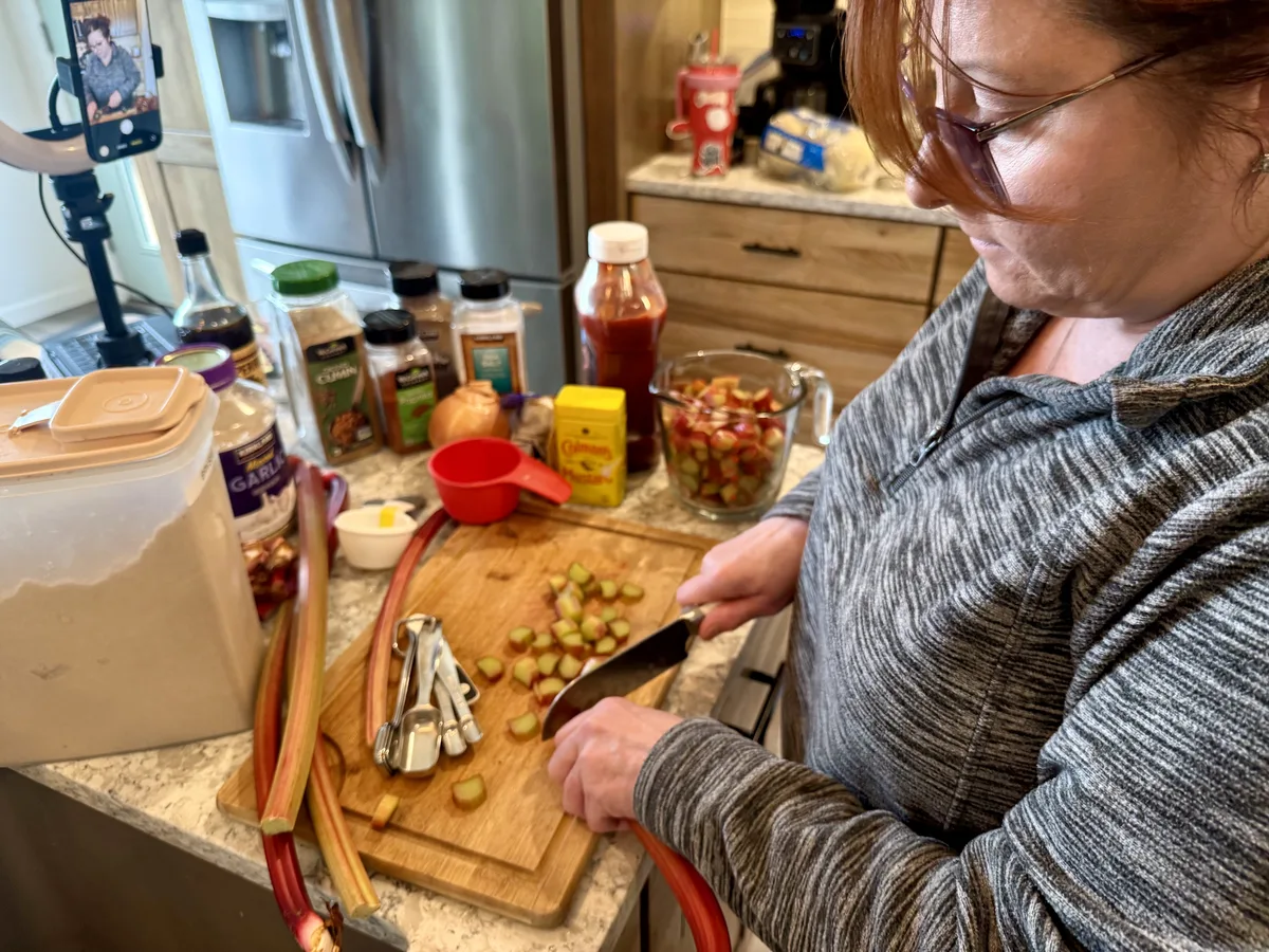 Sherri chopping fresh rhubarb stalks for BBQ sauce at Ravenswood Gardens